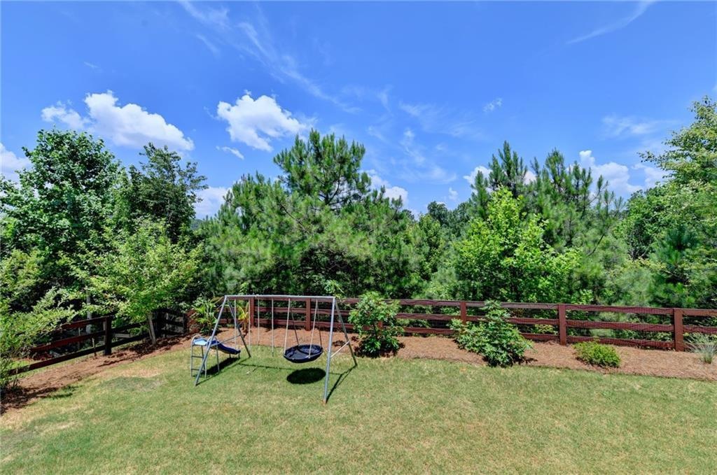 Fenced yard bordered by trees